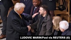 Обраний президент США Дональд Трамп (л) вітається з президентом України Володимиром Зеленським під час урочистостей у Соборі Паризької Богоматері, Париж, 7 грудня 2024 року