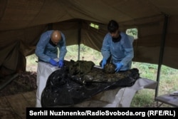 Судово-медичні експерти Антон Харченко (ліворуч) та Галіє Мустафіна (праворуч) проводять повний огляд тіла та намагаються відновити папілярний візерунок кінцівок