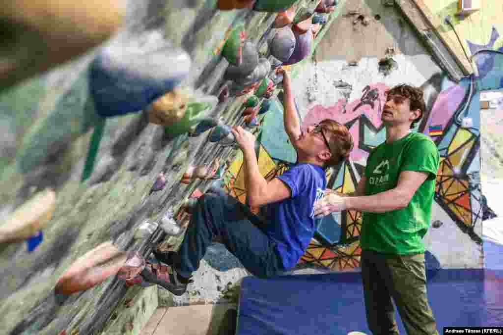 Claudiu Miu, fondatorul Climb Again, ghidează un sportiv cu deficiențe de vedere în timpul unui antrenament la Fabrica de Cățărat din București.