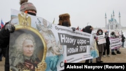 Imagine de la un protest din Kasahstan, din 2021. Vladimir Putin a fost adesea portretizat, ironic, cu imaginea foștilor țari, din cauza mesajelor sale imperialiste, de extindere a teritoriului Rusiei. 