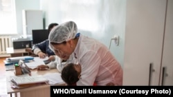 Мальчик обнимает врача после того, как ему сделали прививку во время дополнительных кампаний по иммунизации в ответ на вспышку кори. Фото: ВОЗ/Даниль Усманов