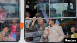 North Koreans look out of a tram as it passes by a department store in central Pyongyang. While some basic shopping is permitted, most North Koreans lived in poverty and rely on the state ration system for survival. 