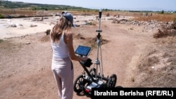 Një anëtare e ekipit duke drejtuar radarin e gjeofizikës për kërkime të radhës nëntokë.