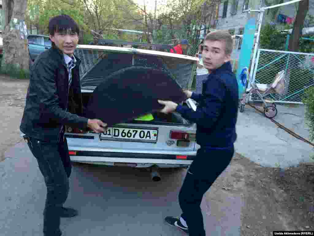 Ребята привезли казан в дом, где готовились к поминкам. Парень слева говорит: "Мы дружные, не спрашиваем о национальности".