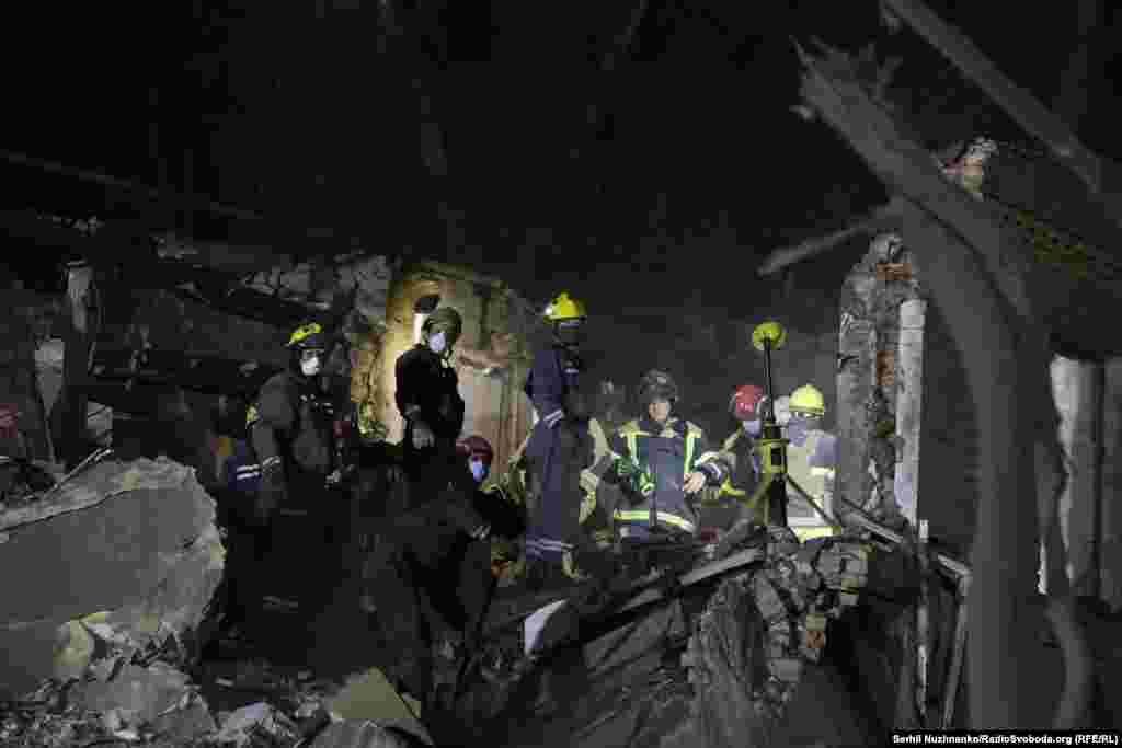 Rescuers work at the site of the attack in Kyiv's Svyatoshynskiy district.