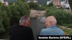 Dy qytetarë duke shikuar ecurinë e punimeve në njërën nga urat e reja mbi Ibër.