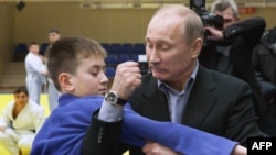 Vladimir Putin, pe vremea când era prim-ministru, arată o mișcare din judo unui tânăr din orașul siberian Kemerovo, pe 24 ianuarie 2012.