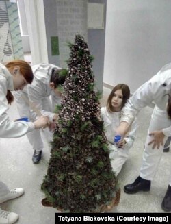 Ірина з одногрупниками прикрашає ялинку у коледжі