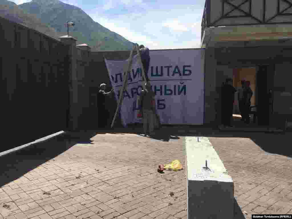 Алмазбек Атамбаевдин талапкерлери "элдик штаб" деген плакатты илип жатышат.