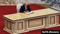 Alyaksandr Lukashenka signs a document after taking the oath of office during a hastily called "inauguration" in Minsk on September 23.