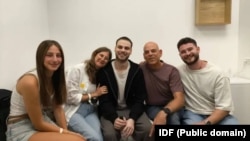 Ostaticul eliberat Alon Ohel (centru) împreună cu familia sa la baza armatei israeliene Re'im.