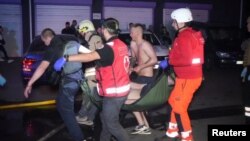 Salvatorii transportă o persoană rănită într-un bloc locativ din Odesa lovit de o dronă rusească. Imagine difuzată pe 28 iunie 2025 de Serviciul de Urgență de Stat al Ucrainei.