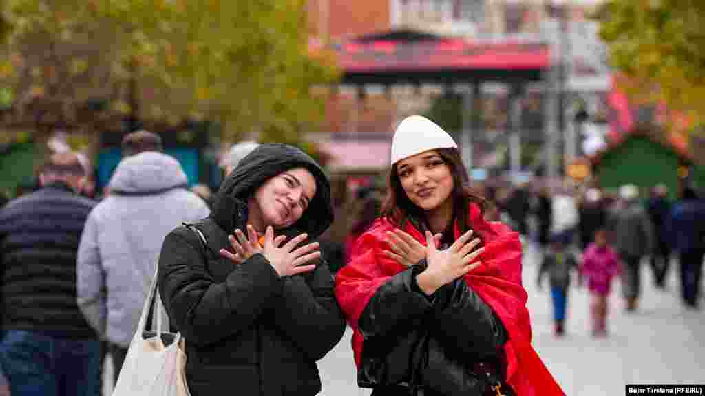 Dy vajza në Prishtinë bëjnë simbolin e shqiponjës në Ditën e Flamurit kombëtar shqiptar. 