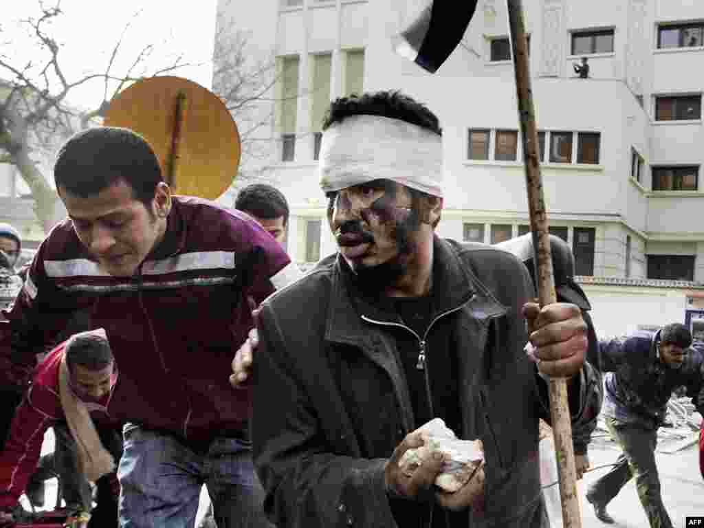 Protesters run for cover as police fire on crowds near a central square in Cairo on January 29.