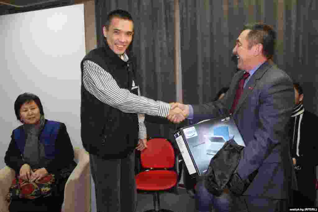 "Азаттыктын" Бишкек бюросунун жетекчиси Султан Жумагулов Назикбек Кыдырмышевге башкы сыйлыкты тапшырууда.