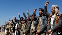 Luptători Houthi și membri ai triburilor organizează un miting împotriva loviturilor americane și britanice asupra siturilor militare conduse de Houthi în apropiere de Sanaa, Yemen, duminică, 14 ianuarie 2024