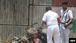 Security officials inspect the scene of a bombing in Karachi on June 10 that killed one person.