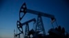 Pump jacks are seen at LUKoil's Imilorskoye oil field. Falling oil prices and revenues are endangering Russia's credit rating.