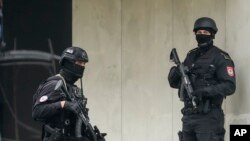 Dva pripadnika Jedinice žandarmerije na ulazu u zgradu Vlade RS u Istočnom Sarajevu, sa prepoznatljivim oznakama ove jedinice, odnosno policije RS, na rukavima.