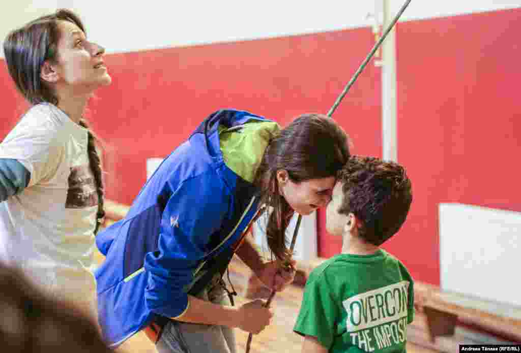 Ana Anton, instructor și PR la Climb Again, salută un copil cu deficiență de auz de la Școala Profesională Specială pentru Deficienți de Auz &bdquo;Sfânta Maria" din București.