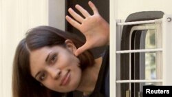 Nadezhda Tolokonnikova, a member of the feminist punk group Pussy Riot, waves from a police van after a court hearing in Moscow on August 8.