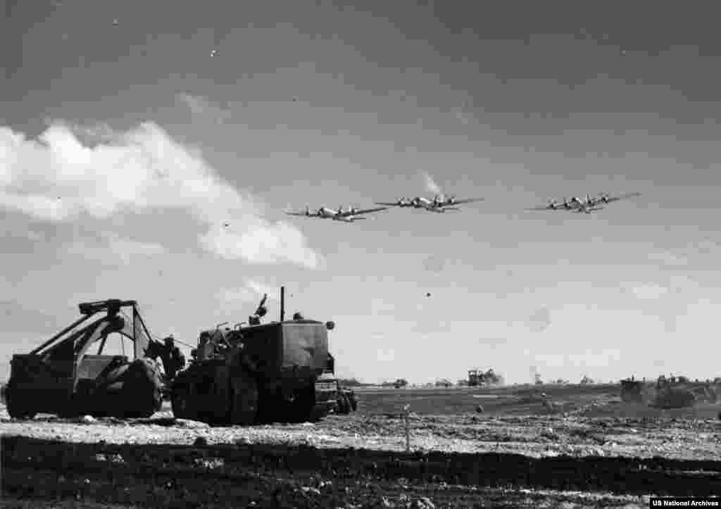 Ingineri militari care lucrează, în iulie 1944, pe insula Tinian după cucerirea acesteia de către forțele americane.Insula a fost un punct militar crucial pentru planificatorii de război americani datorită poziției sale, care plasa Japonia în raza de acțiune a celui mai nou bombardier strategic american al momentului, B-29.