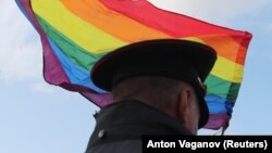 რუსი პოლიციელი ლგბტ დროშის ფონზე - საილუსტრაციო ფოტო.