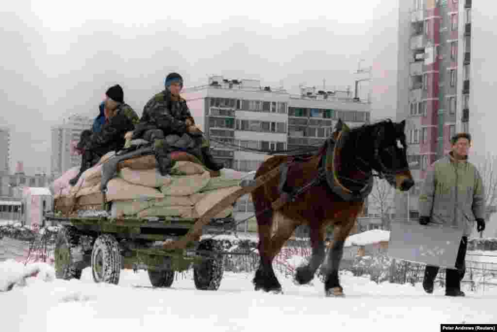 With fuel in short supply, Bosnian army soldiers are forced to use a horse and cart to transport food supplies to the district of New Sarajevo near the airport on January 5, 1995.