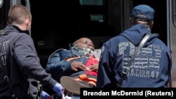 امریکا کې په کرونا ویروس اخته کس د درملنې لپاره روغتون ته لېږدول کېږي.