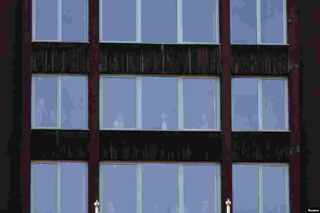 Jutro nakon požara, ljudi gledaju kroz prozore u neoštećenom dijelu zgrade Doma penzionera u Tuzli, Bosna i Hercegovina, 5. novembra 2025.
