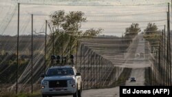 Сигналды басатын құрылғымен жабдықталған көлік тормен қорғалған жолда жүріп келеді. Украинаның шығыс бөлігі, 2 қазан