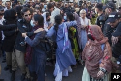 Police officers detain members of the BYC during a protest demanding Mahrang Baloch's release in Karachi, Pakistan, on March 24.