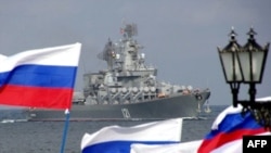 Pro-Russian supporters welcome the missile cruiser "Moskva" to Sevastopol after participating in military operations against Georgia.
