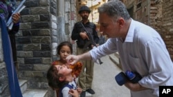 په پېښور کې یو روغتیايي کارکوونکی یوې ماشومې ته د ګوزڼ واکسیني څاڅکي ورکوي - د مې ۲۶مې انځور.