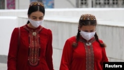 Women wearing protective face masks walk along a street in Ashgabat, the capital of Turkmenistan. (file photo)