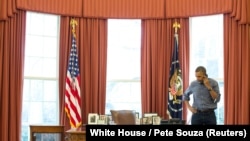 U.S. President Barack Obama talks on the phone in the Oval Office with Russian President Vladimir Putin about the situation in Ukraine. 