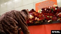 People lay flowers and candles at the Lubyanka subway station