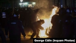 Forțele de ordine încearcă să stingă un incendiu la protestul din apropierea BEC, pe 9 martie 2025.