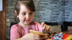 Молодша дочка Абдуллаєвих, Аят, грає книгою