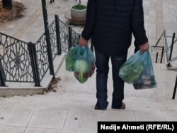 Një qytetar duke u kthyer nga Tregu i Gjelbër në Ulpianë, Prishtinë, pas një dite pazari, 8 dhjetor.