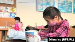 Две школьницы на уроке во время пандемии коронавируса.