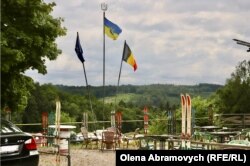 Прапори ЄС, України та Бельгії на терасі, паркан якої прикрашений лижами на згадку про часи, коли на Франкоплі взимку було сніжно