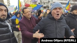 Un bărbat încearcă să liniștească un manifestant care huiduie o echipă de jurnaliști la protestul AUR, pe 12 ianuarie 2025.