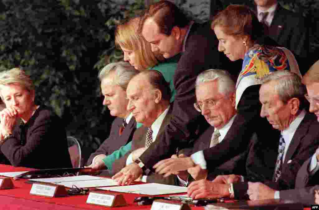 Leaders sign their initials on the draft of the Dayton peace agreement on November 21, 1995, at the conclusion of the Proximity Peace Talks at the Wright Patterson Air Force Base near Dayton, Ohio. Serbian President Slobodan Milosevic is sitting second from the left. To his left are Bosnian President Alija Izetbegovic, Croatian President Franjo Tudjman and U.S. Secretary of State Warren Christopher.