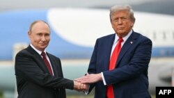 Президент США Дональд Трамп вітає президента Росії Володимира Путіна на злітній смузі після їхнього прибуття на базу Елмендорф-Річардсон в Анкориджі, Аляска, 15 серпня 2025 року