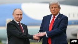 US President Donald Trump (right) greets Russian President Vladimir Putin on the tarmac at Joint Base Elmendorf-Richardson in Anchorage, Alaska, on August 15.