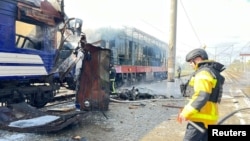 Un pompier lângă un tren de călători lovit de drone rusești la Șostka, 4 octombrie 2025