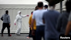 Германиянын Хамм шаарындагы эт комбинатынын кызматкерлери текшерүүдөн өтүп жатышат, 10-май 2020-жыл.