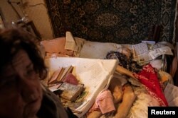 Inna Khristici stă în dormitorul ei lângă cadavrul soțului ei, Olexandr Khristici, un bărbat în vârstă de 79 de ani care a fost ucis într-un atac cu rachete rusești asupra blocurilor de locuințe din Harkov. Putin continuă să susțină că nu atacă decât ținte militare.