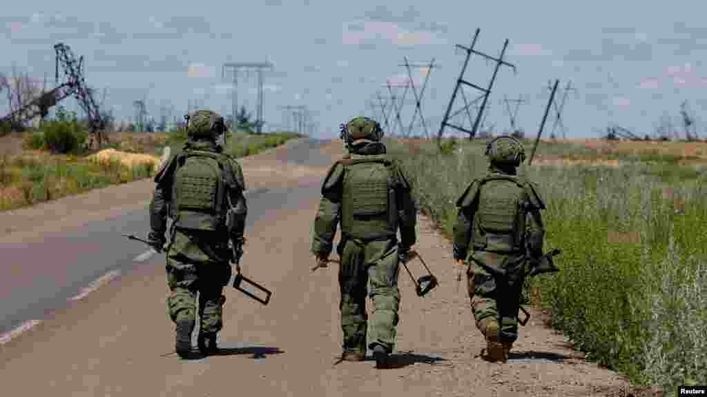 Ruski saperi hodaju duž autoputa blizu okupiranog ukrajinskog grada Marinka dok traže eksplozive i sprovode operacije razminiranja.